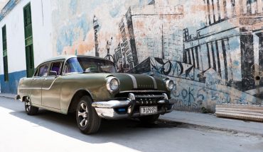 50's car in front of mural in Havana